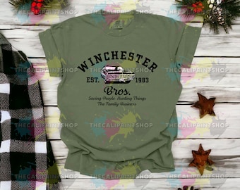 May include: Green t-shirt with a black and white graphic of a car and the text "Winchester Est. 1983 Bros. Saving People Hunting Things The Family Business"