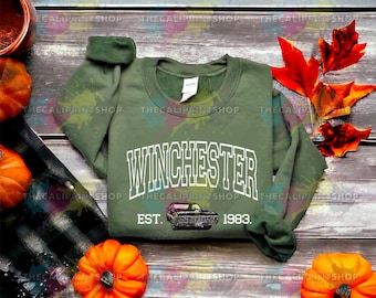May include: Green sweatshirt with white text that reads "Winchester Est. 1983."  A black car is printed below the text.