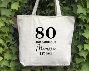 May include: White canvas tote bag with black text that reads "80 and Fabulous Merissa Est. 1943".