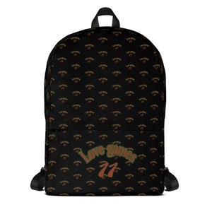 May include: Black backpack with a repeating pattern of the text "Love Games 77" in brown and red. The text "Love Games 77" is also printed in a larger size on the bottom of the backpack in green, red, and brown.