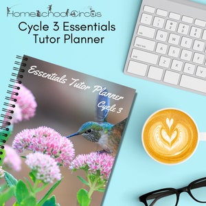 May include: A spiral-bound planner titled Essentials Tutor Planner Cycle 3 featuring a hummingbird on pink flowers. The cover includes the text Homeschool Circus Cycle 3 Essentials Tutor Planner. A white keyboard and a cup of coffee are nearby.
