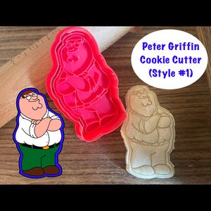 May include: Red plastic cookie cutter shaped like Peter Griffin from Family Guy. The cutter is shown next to a cookie that has been cut out using the cutter. The cookie is a light brown color.