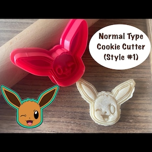 May include: A red plastic cookie cutter in the shape of a cartoon character, next to a baked cookie of the same design. The text "Normal Type Cookie Cutter (Style #1)" is in a white oval.