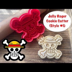 May include: Red plastic cookie cutter shaped like a skull with a straw hat and crossbones. A cookie cut with the same design is shown next to it.
