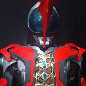 May include: A red and black superhero costume with a gold chest piece and a red and white helmet with a blue visor.