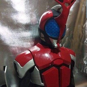 May include: A red and silver costume with a helmet featuring a blue visor and a red and black antenna. The costume is a popular character from a Japanese television show.