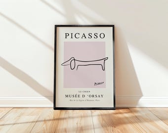 May include: A black framed print with a minimalist line drawing of a dachshund on a light pink background. The print features the text "PICASSO" at the top and "LE CHIEN MUSEE D'ORSAY" at the bottom.