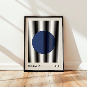 Könnte beinhalten: Ein schwarz-weiß gestreiftes Poster mit einem blauen Kreis in der Mitte. Das Poster trägt den Text "BAUHHAUS" und "1919" unten.