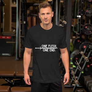 Könnte beinhalten: Dunkelgraues T-Shirt mit dem weißen Text "ONE FLESH, ONE END." und einem Schwert-Grafik. Die Person trägt das Shirt in einem Fitnessstudio.