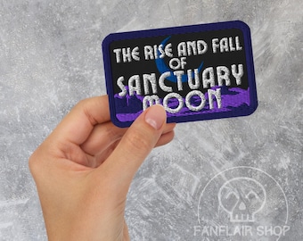 May include: A rectangular patch with the text "THE RISE AND FALL OF SANCTUARY MOON" in white, blue, and purple. The patch has a dark blue border and is held by a hand. The Fanflair Shop logo is in the bottom right corner.