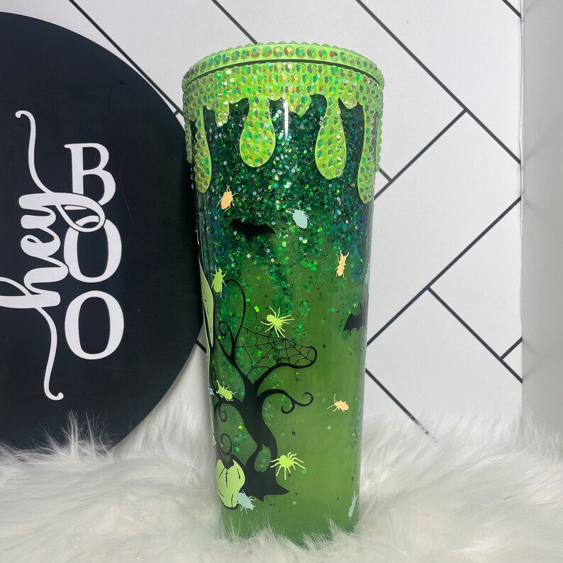 Peut inclure: Gobelet vert &agrave; paillettes avec un motif d'araign&eacute;e et de chauves-souris noires. Le haut du gobelet est d&eacute;cor&eacute; de strass verts et a un effet de slime qui coule.