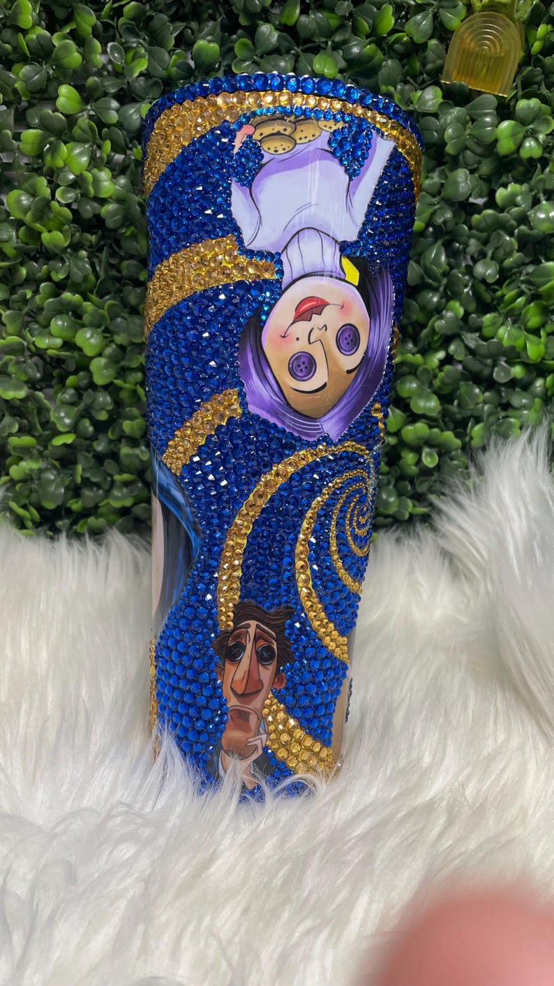May include: A blue and gold tumbler with a swirling pattern and images of characters from the film "The Nightmare Before Christmas".