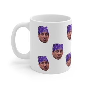 May include: White ceramic mug with a purple bandana pattern featuring a repeated image of a man's face.