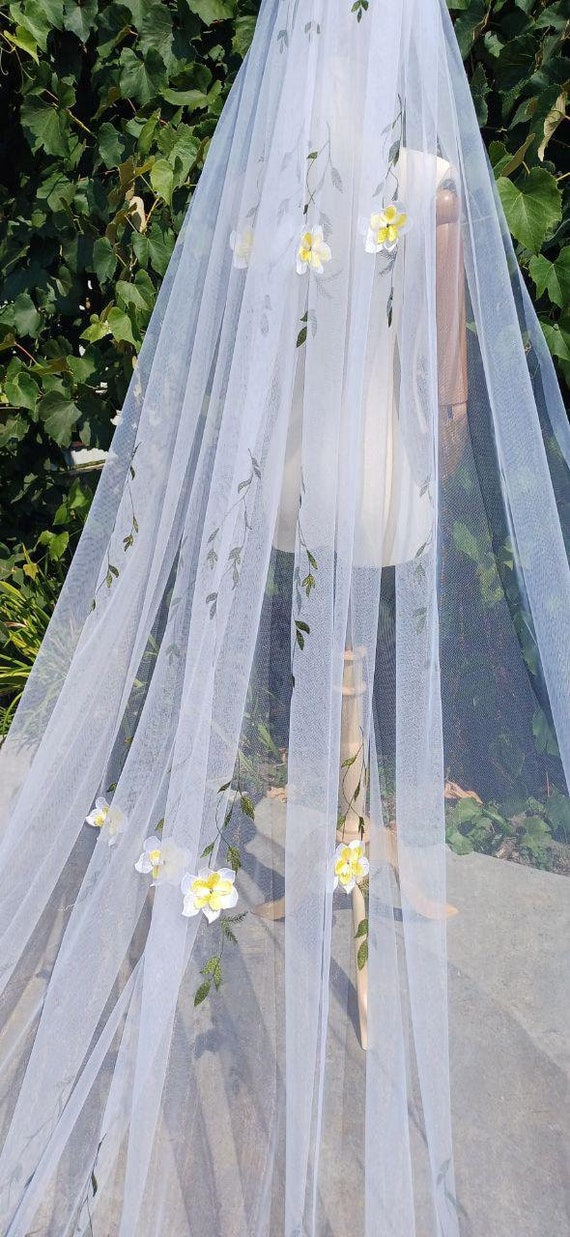 Wedding veil with colorful flower embroidery, accented with lemon and green leaves, is one tier and attached to the comb.