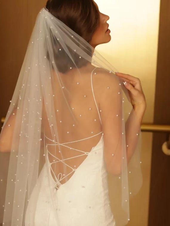 Wedding veil of soft tulle with pearls along the entire length in one tier on the comb