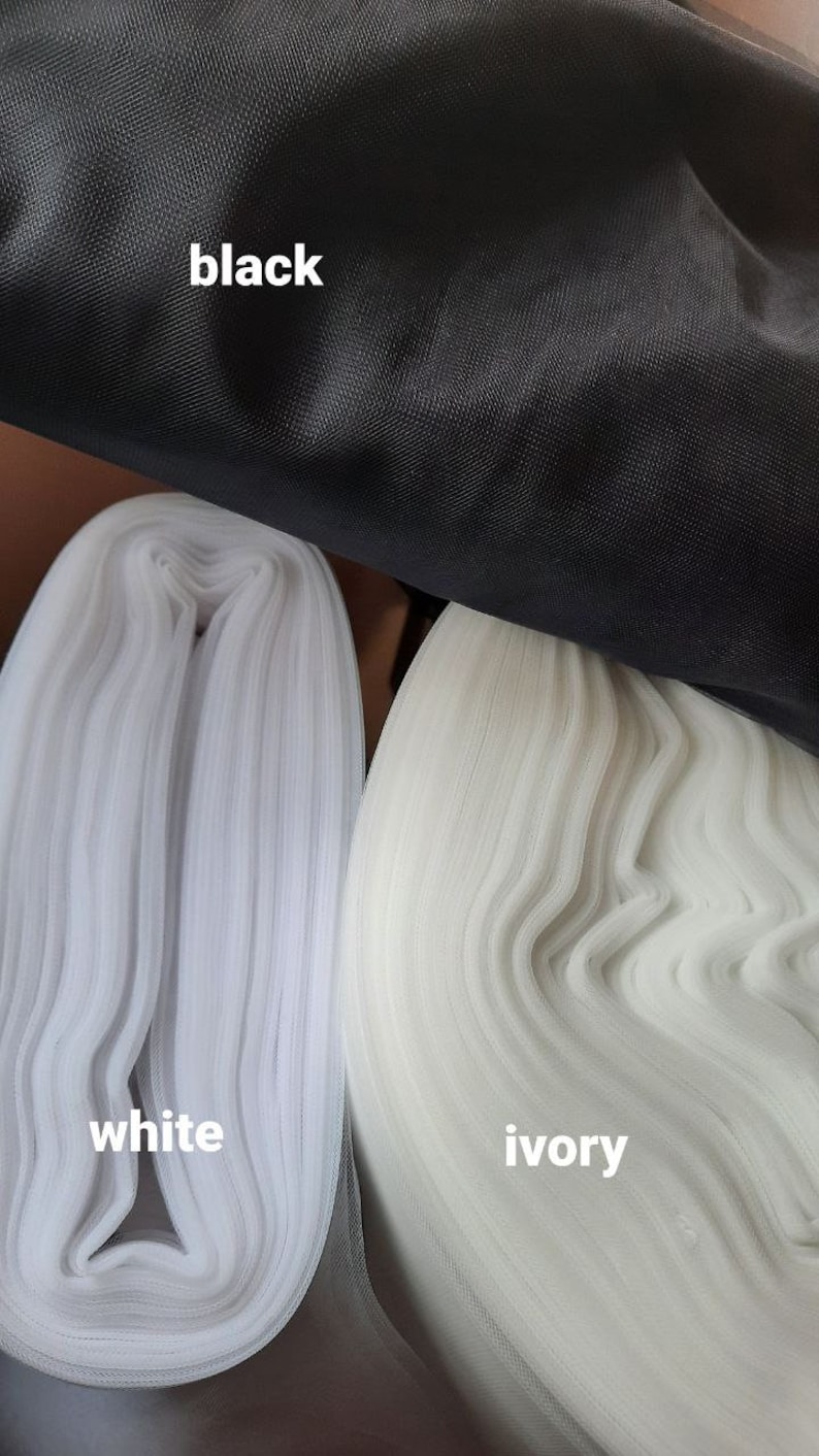 May include: Close-up of three fabric swatches: black, white and ivory. The fabric is a fine mesh.