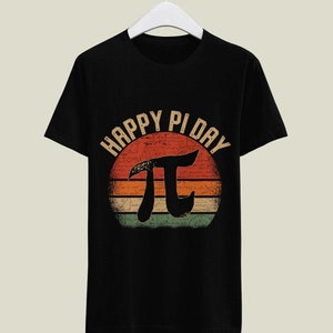 May include: Black t-shirt with a vintage-style graphic of a sunset with the text "Happy Pi Day" and the mathematical symbol for pi.
