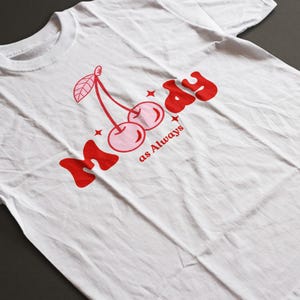 May include: White t-shirt with a red graphic of two cherries and the text "Moody as Always".