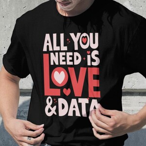 May include: Black t-shirt with a pink and red graphic that says "All You Need Is Love & Data".