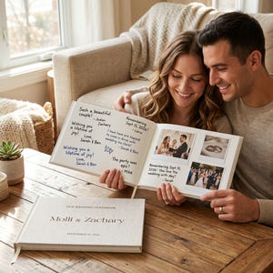 May include: A couple looks at a wedding guest book with photos and handwritten messages. The book on the table is labeled "Molli & Zachary" with the date "September 15, 2020". The open book shows photos and handwritten notes.