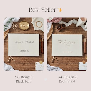 May include: Two wedding guest books with linen covers are displayed on a wooden surface. One book has black text that reads "Anna & Michael" and "Mandeville, LA September 13, 2026." The other book has brown text that reads "The Wilsons" and "EST. 2026."