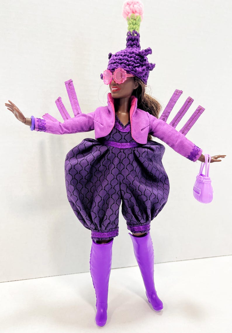 May include: A doll dressed in a purple outfit, featuring a jacket, jumpsuit, and boots. The doll wears a distinctive hat, pink sunglasses, and carries a matching handbag. The jumpsuit has a geometric pattern. The doll's ensemble is a vibrant display of purple.