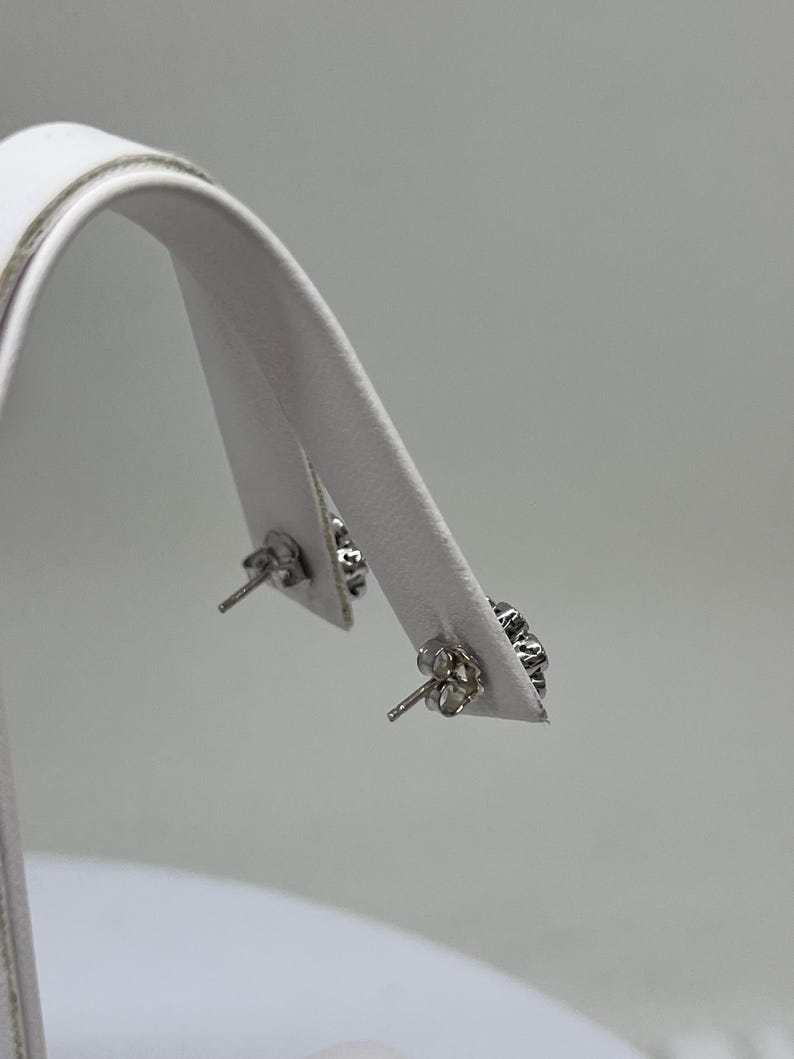 Op de afbeelding: Een paar zilveren oorbel studs met heldere kristallen accenten.