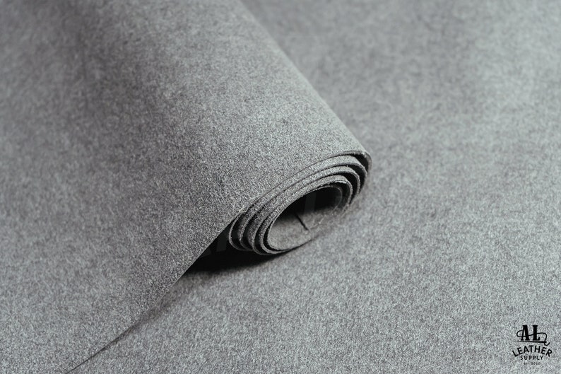 May include: A roll of gray felt fabric. The fabric is soft and has a slightly textured surface.