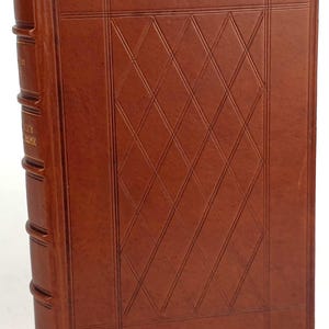 K&ouml;nnte beinhalten: Ein braunes, ledergebundenes Buch mit einem gepr&auml;gten Rautenmuster auf dem Einband. Das Buch hat einen goldfarbenen R&uuml;cken mit dem Text "The Complete Works of Edgar Allan Poe".