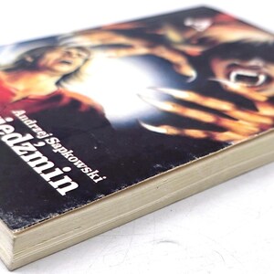 K&ouml;nnte beinhalten: Ein Taschenbuch mit dem Titel "wiedzmin" von Andrzej Sapkowski. Das Cover zeigt eine dramatische Illustration mit einer Figur, die ein Schwert h&auml;lt, und einem Monster mit scharfen Krallen und Z&auml;hnen. Das Buch hat ein abgenutztes Aussehen.