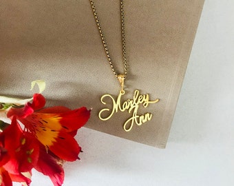 May include: Gold necklace with a pendant featuring the names "Marley Ann" written in cursive script.