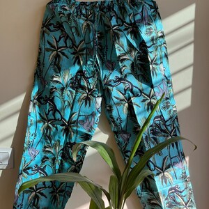 May include: Blue pajama pants with a tropical print featuring palm trees and monkeys.