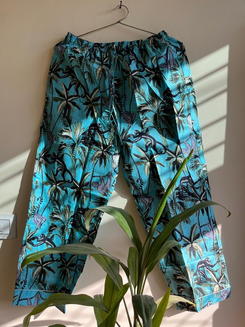 May include: Blue pajama pants with a tropical print featuring palm trees and monkeys.