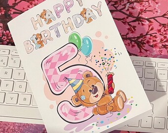 May include: A birthday card with the words "HAPPY BIRTHDAY" in bubble letters, decorated with teddy bears. The number "5" is pink with a checkered pattern. A cartoon teddy bear wearing a party hat and holding a firecracker is featured.