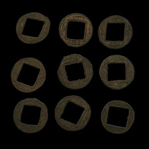May include: Nine antique bronze coins with square holes in the center are arranged against a black background. The coins have a circular shape with a square cut out in the middle. The coins have a weathered appearance, suggesting age and use.