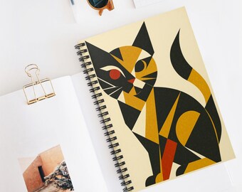 Op de afbeelding: Spiraalgebonden notitieboek met een geometrisch kattenontwerp in zwart, goud en rood. De kattenillustratie staat op een crèmekleurige achtergrond. Het notitieboek is open en toont blanco pagina's en een gouden paperclip.