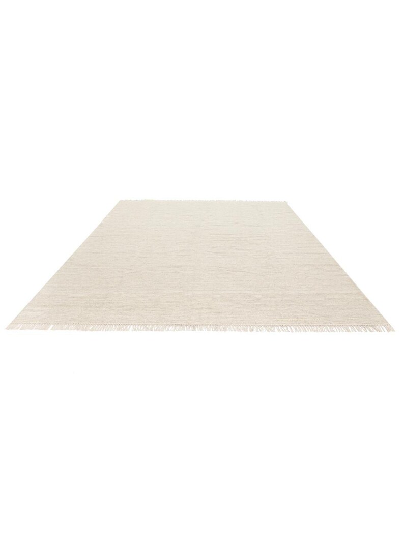 May include: A plain white rug with a fringed edge.