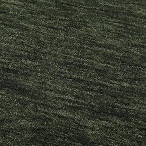 May include: Close-up of a textured, dark green rug. The rug has a dense, looped pile with a subtle, diagonal pattern. The color is a deep, muted green, with variations in tone creating visual interest. The rug appears soft and inviting.