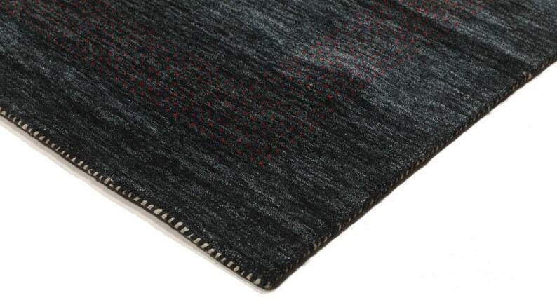 May include: Close-up of the edge of a dark gray rug with a subtle pattern. The rug has a white stitched border.