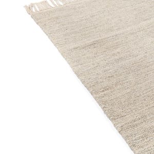 May include: A beige woven rug with fringe on the edges.