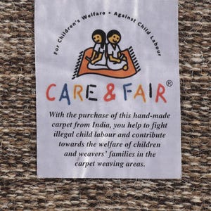 May include: White label with the text "For Children's Welfare. Against Child Labour" and the logo "CARE & FAIR" with two children sitting on a rug. The text below the logo reads "With the purchase of this hand-made carpet from India, you help to fight illegal child labour and contribute towards the welfare of children and weavers' families in the carpet weaving areas."