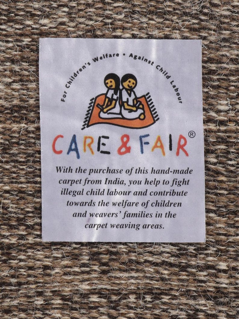 May include: White label with the text "For Children's Welfare. Against Child Labour" and the logo "CARE & FAIR" with two children sitting on a rug. The text below the logo reads "With the purchase of this hand-made carpet from India, you help to fight illegal child labour and contribute towards the welfare of children and weavers' families in the carpet weaving areas."