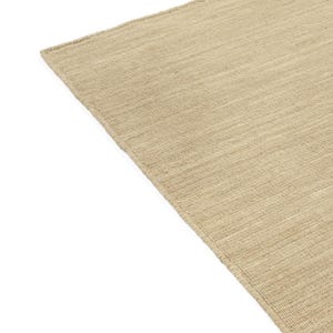 May include: A close-up of a beige woven rug with a subtle texture. The rug has a slightly rough, natural feel.