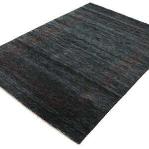 May include: A dark gray area rug with a subtle pattern. The rug has a soft, textured feel and is made of high-quality materials.