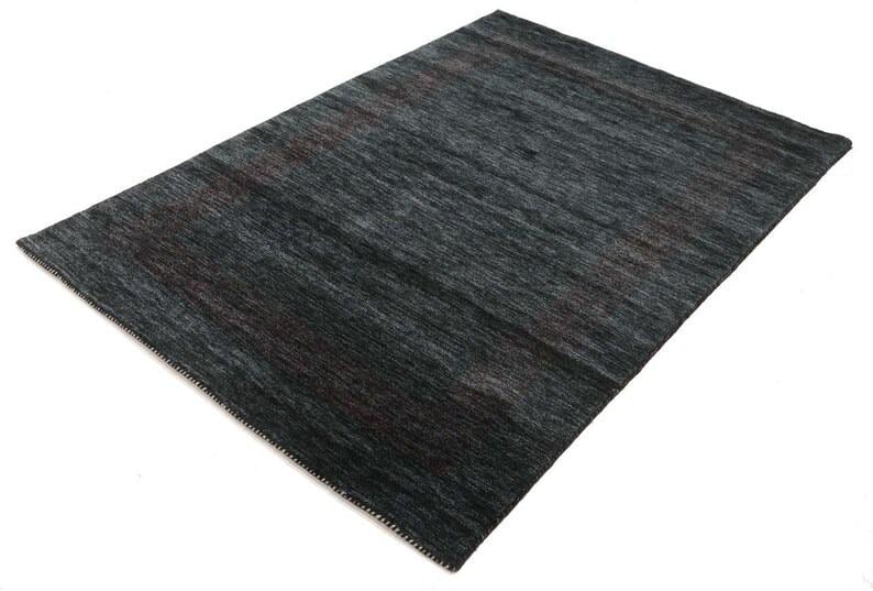 May include: A dark gray area rug with a subtle pattern. The rug has a soft, textured feel and is made of high-quality materials.