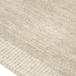 K&ouml;nnte beinhalten: Nahaufnahme eines gewebten Teppichs in Beige und Wei&szlig; mit einer strukturierten Oberfl&auml;che. Der Teppich hat ein dezentes Muster aus Streifen.