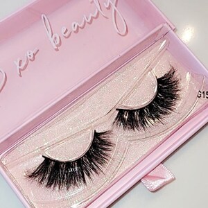 May include: A pair of false eyelashes in a pink box with glitter. The box has the text "xo beauty" on the top.