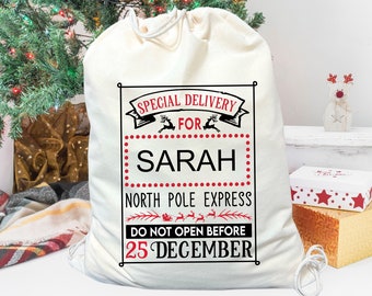 May include: A white canvas Santa sack with a red and black design. The sack has the text "Special Delivery for Sarah North Pole Express Do Not Open Before 25 December".