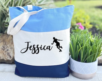 May include: A blue, white, and navy blue tote bag with the name "Jessica" and a silhouette of a figure ice skating.