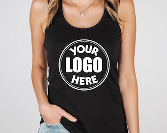 May include: Black racerback tank top with a white circular logo that reads "YOUR LOGO HERE". The tank top is sleeveless and has a scoop neck. The model is wearing blue jeans.